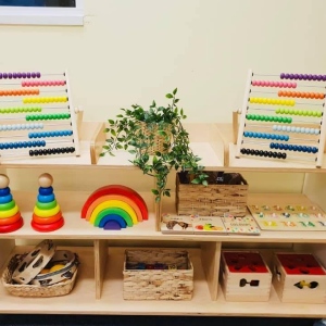 Montessori-style learning shelf with rainbow stacker, abacus and educational toys at Innovative Early Learning