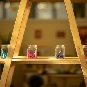 Wooden art easel with colorful glass jars for children's creative activities at Innovative Early Learning