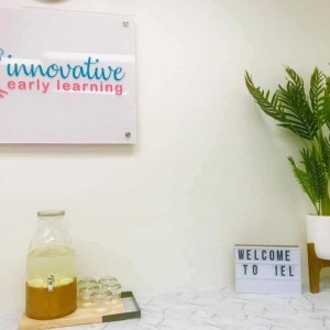 Innovative Early Learning centre sign with classroom shelf and potted plant